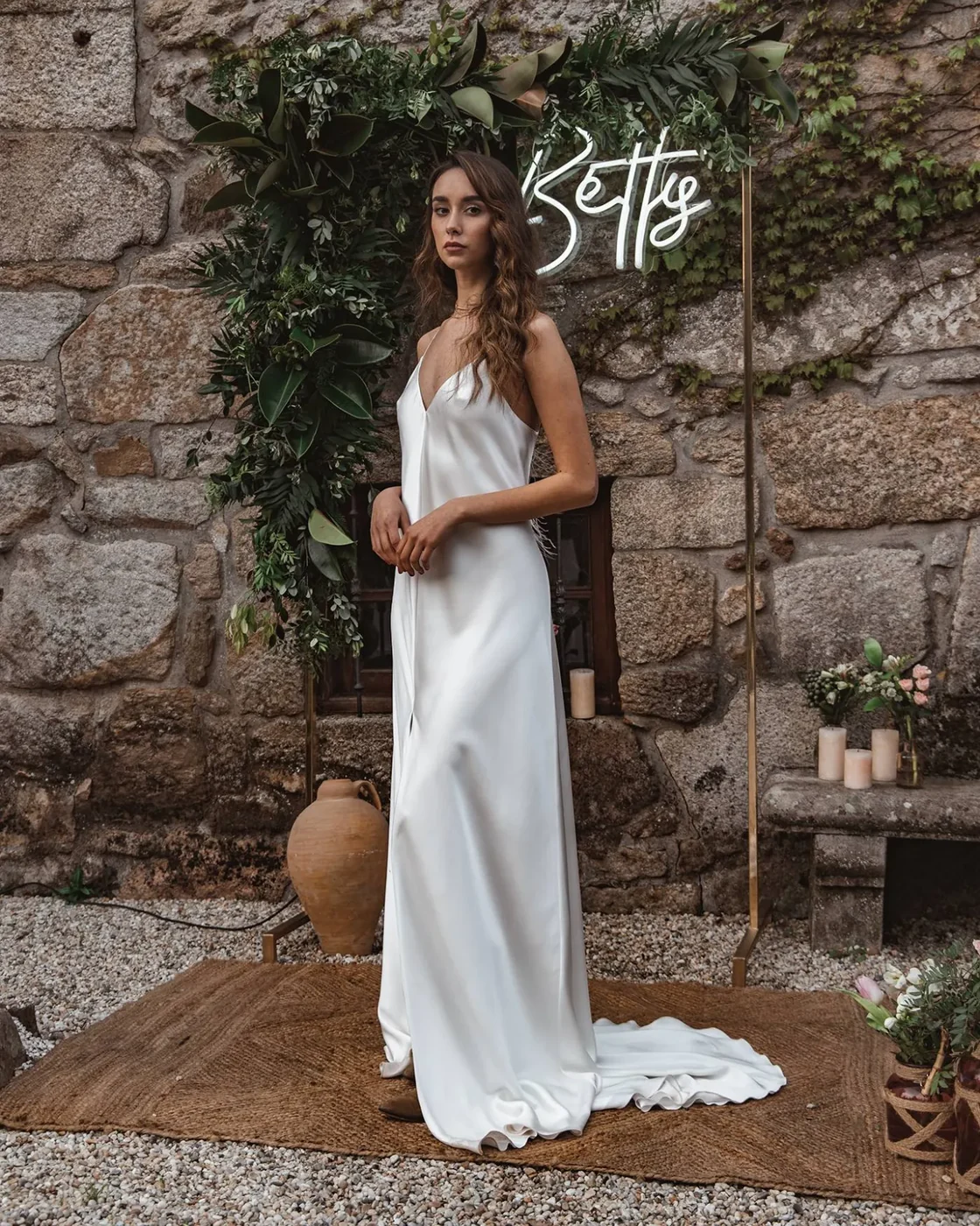 Novia con vestido blanco en el jardín de Betty Peluquerías