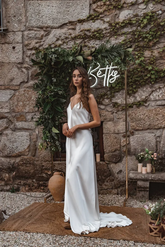 Novia con vestido blanco ante el letrero de Betty Peluquerías